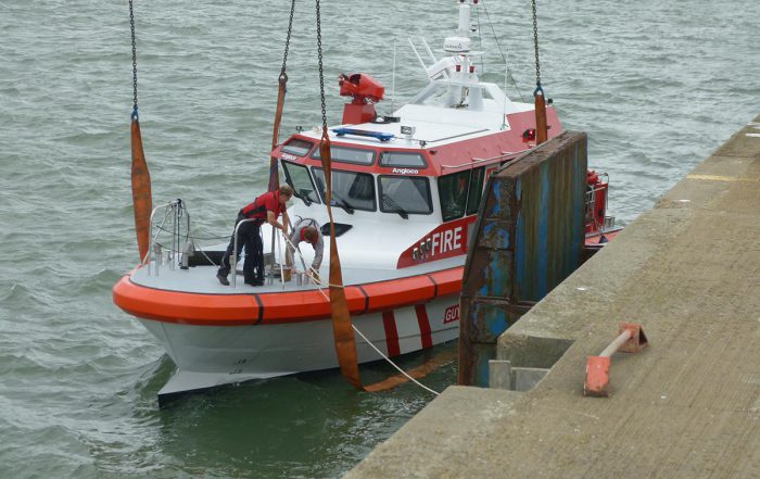 Boat being lifted from water to be shipped from the UK to the Caribbean